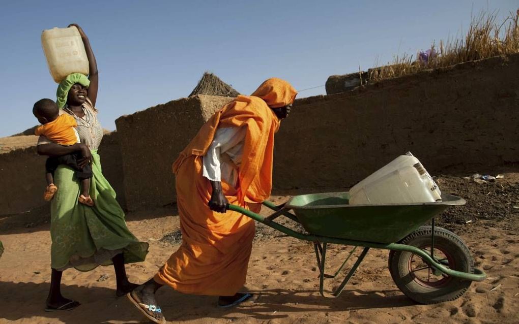 Kariya Mohamed Abbakar (50) moet een flink eind lopen voor ze haar jerrycan kan vullen met water. En dan de zware terugreis nog. Foto EPA