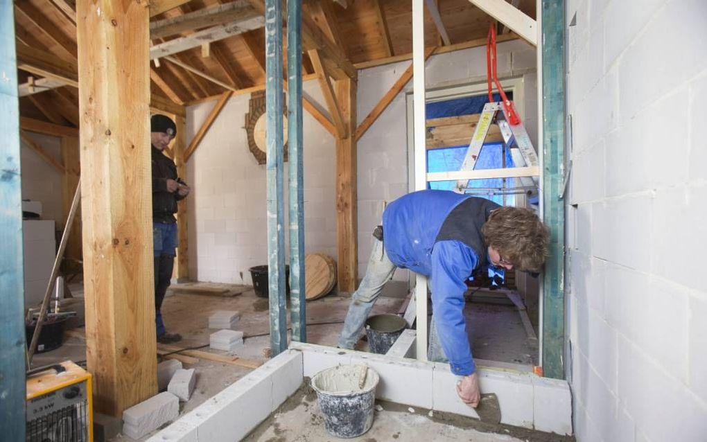 Leerlingen van vakopleiding Revabo zijn aan het werk met de herbouw van de oude graanschuur op De Appelhof in Lunteren. Foto Herman Stöver