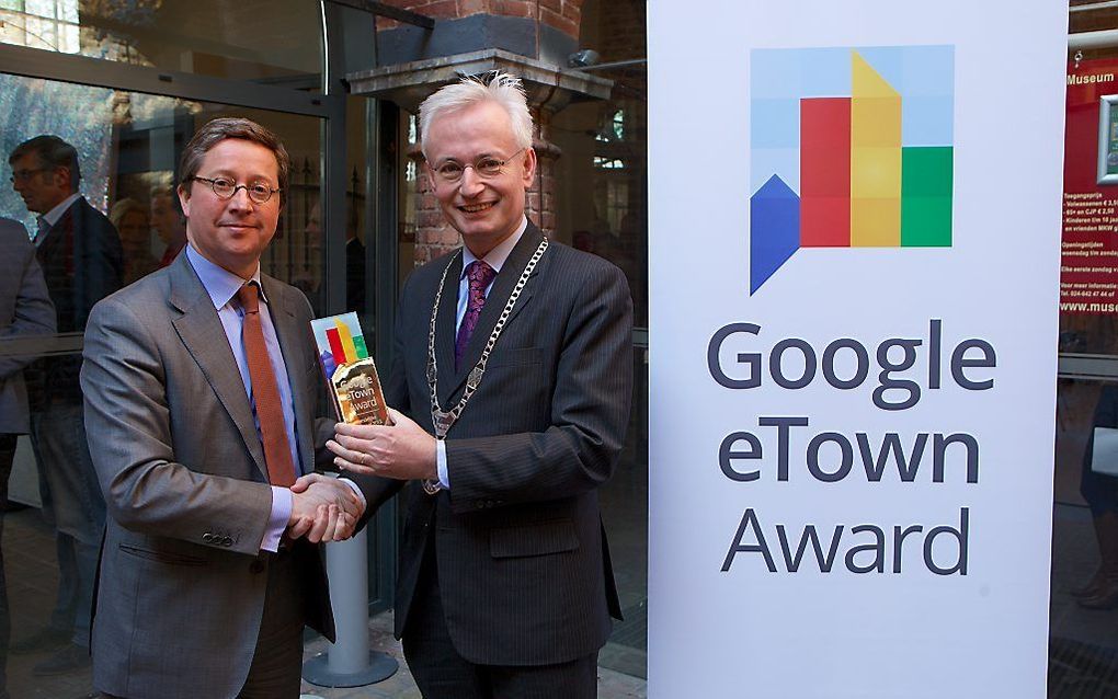 Googledirecteur Pim van der Feltz en burgemeester Verheijen van Wijchen met de eTown Award. Foto Ernst van Deursen