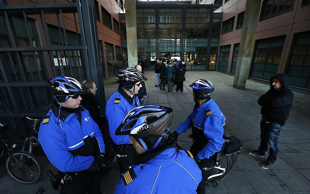 Politieagenten houden de wacht bij de rechtbank voorafgaand aan de inhoudelijk behandeling van de zaak Vaatstra.  Foto ANP