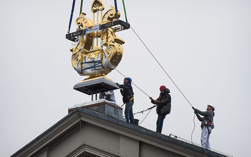 De gouden lier van het Concertgebouw in Amsterdam wordt, na een opknapbeurt, op zijn plek gezet. Foto ANP