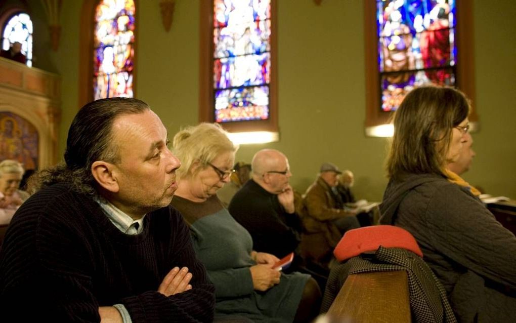 In de Haagse Jozefkapel luisteren de bezoeker van een viering naar de uitleg van een Bijbelgedeelte door straatpastor Klaas Koffeman.  beeld Gerhard van Roon