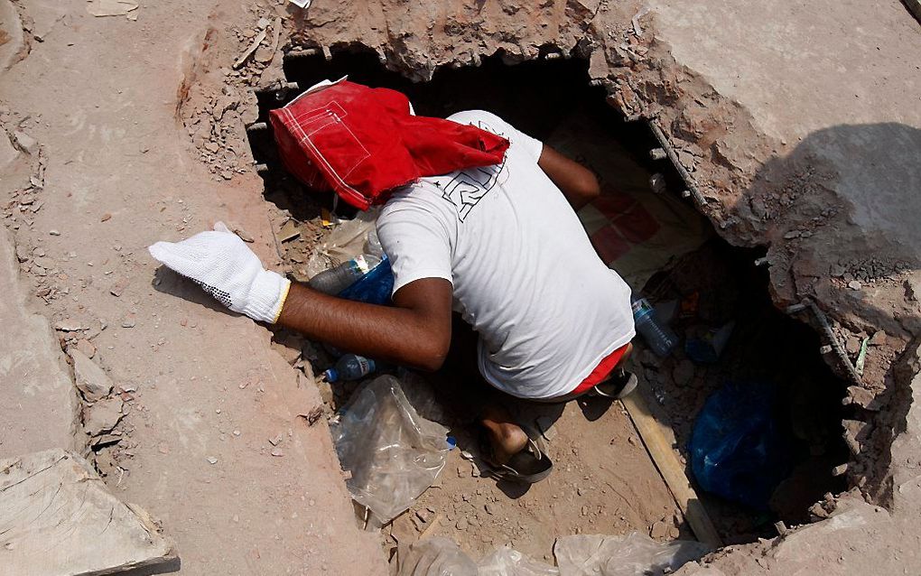 Reddingswerkers zijn er donderdagavond laat in geslaagd 41 mensen levend uit het ingestorte gebouw in Bangladesh te redden. Het dodental is inmiddels opgelopen tot zeker 260. Beeld EPA