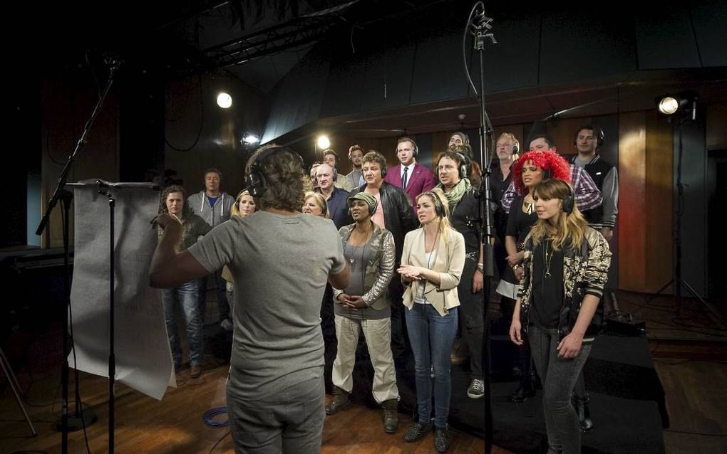 Een groep bekende Nederlanders met op de voorgrond componist John Ewbank, bij het inzingen van het Koningslied. Foto ANP