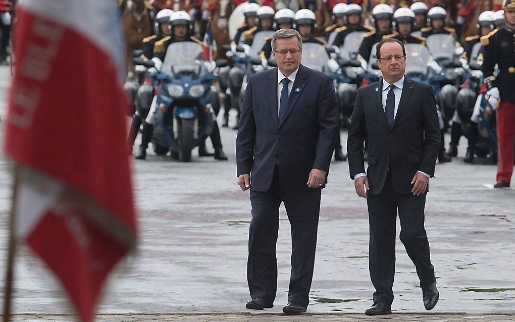 De Poolse president Komorowski arriveert met zijn Franse collega Hollande bij de Arc de Triomphe in Parijs. Foto EPA