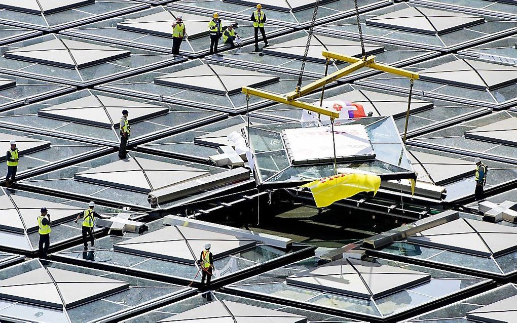 Het laatste glazen dakdeel wordt op station Den Haag Centraal geplaatst. Het station krijgt in 2014 ook een compleet nieuw gebouw waar alle openbaar vervoer bij elkaar komt.  Foto ANP