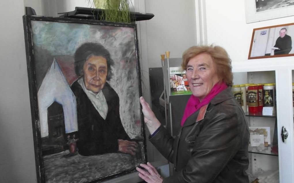 Gids Ludwine Degrieck bij een portret van Marcella Pattyn, de laatste begijn ter wereld. beeld RD