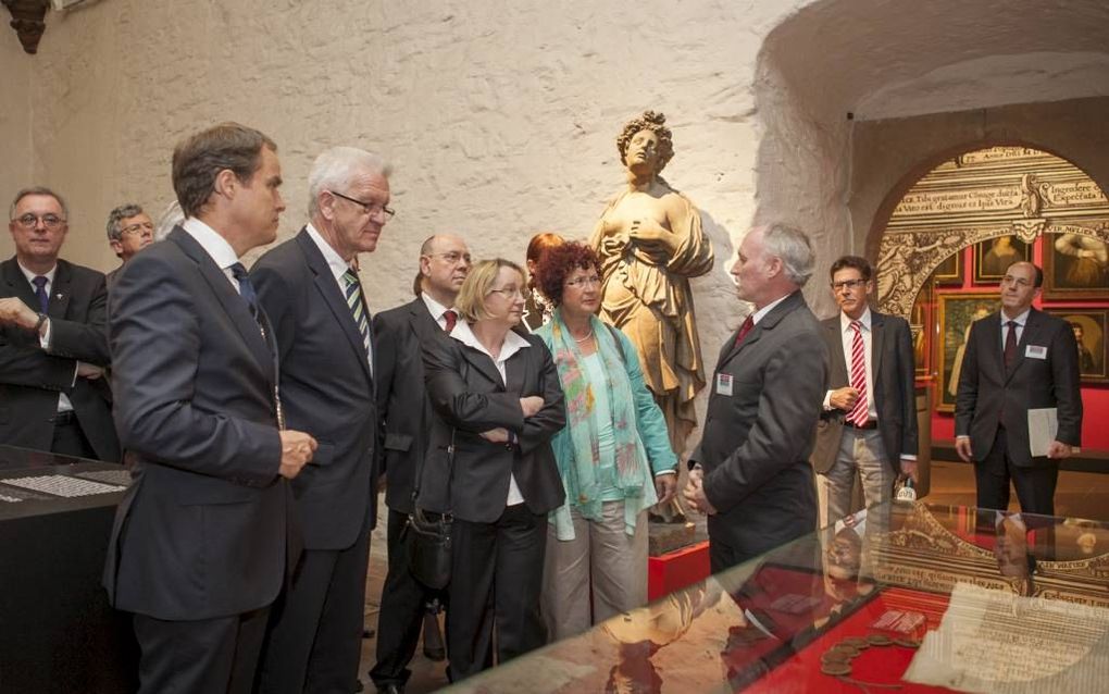 Dr. Wolfgang Wiese, hoofdconservator van de tentoonstelling in slot Heidelberg, geeft uitleg  aan v.l.n.r. burgemeester Würzner, ministerpresident van Baden-Württemberg Kretschmann en Nikolaus Schneider, voorzitter van de raad van de Evangelische Kirche i