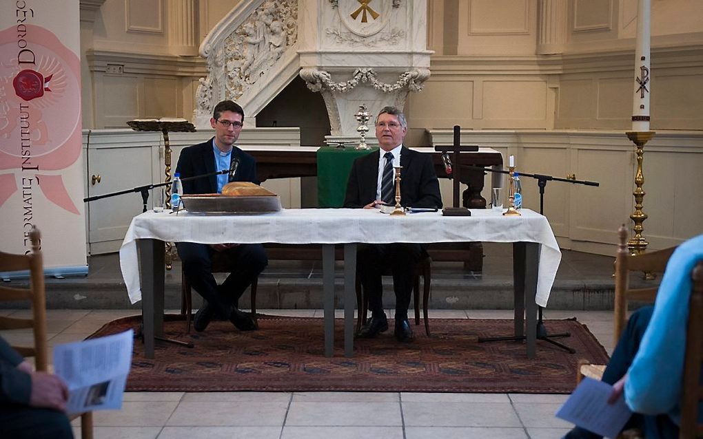 In de Trinitatiskapel in Dordrecht gingen ds. J. M. J. Kieviet (r.) en pastoor Tj. Visser vrijdagavond met elkaar in gesprek over het heilig avondmaal. Uitgangspunt was vraag en antwoord 80 van de Heidelbergse Catechismus, die 450 jaar bestaat. Beeld Cees