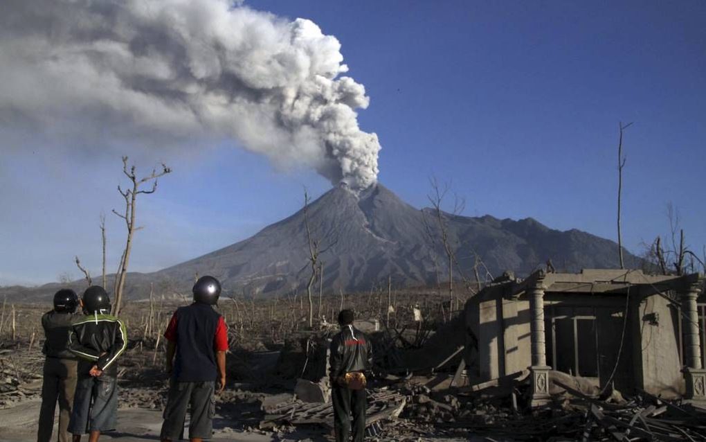 Mensen kijken naar een uitbarsting van de vulkaan Merapi. Bij verschillende erupties maakte de vulkaan de afgelopen jaren veel slachtoffers. Het beschikbare geld voor herstelwerkzaamheden werd door lokale politici niet altijd goed gebruikt. Foto EPA