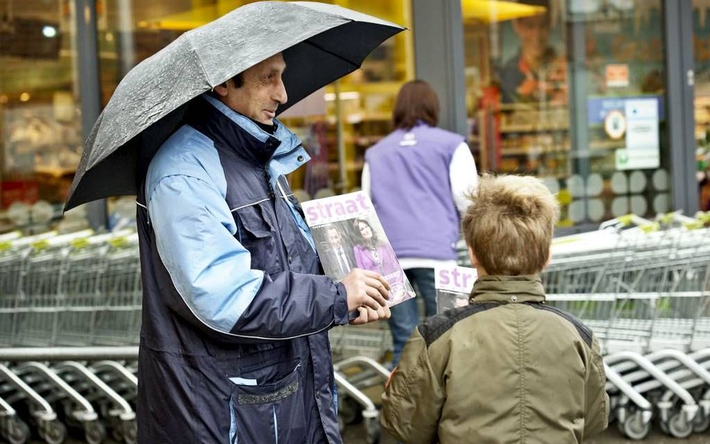 Een Roma uit Oost-Europa verkoopt straatkranten bij een supermarkt. beeld Dick Vos