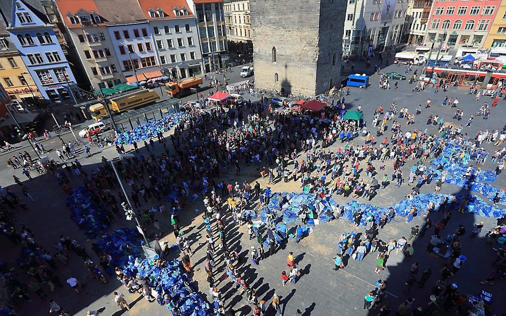 Mensen vullen zandzakken op een plein in Halle. Foto EPA