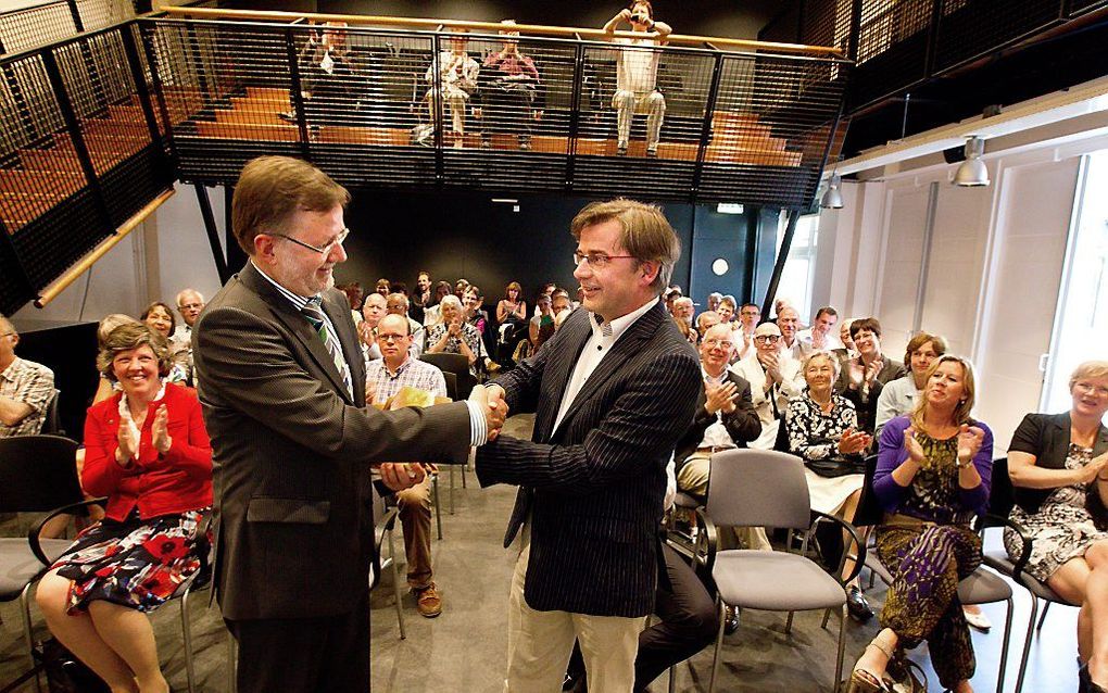 Uitgever Arjen van Trigt overhandigde vrijdag in Utrecht het boek ”Overvloed en overgave. Een caleidoscopisch geloofsboek” aan dr. A. J. Plaisier. Beeld Anton Dommerholt