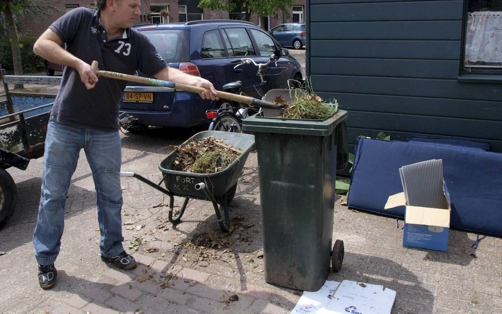 Een vrijwilliger van Stichting Present aan het werk in de tuin van een burger in de marge van de samenleving. Beeld Tekstbureau Vakmaten