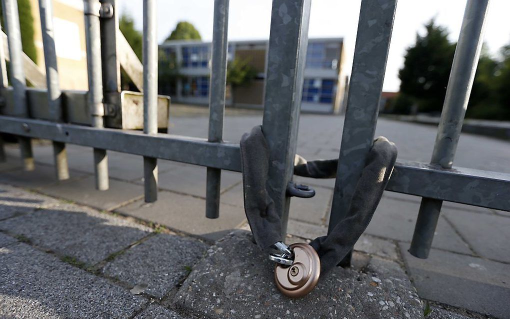 Actievoerders van Identitair Verzet hebben een kettingslot om de hekken van de Ibn Ghaldounschool gedaan. Foto ANP