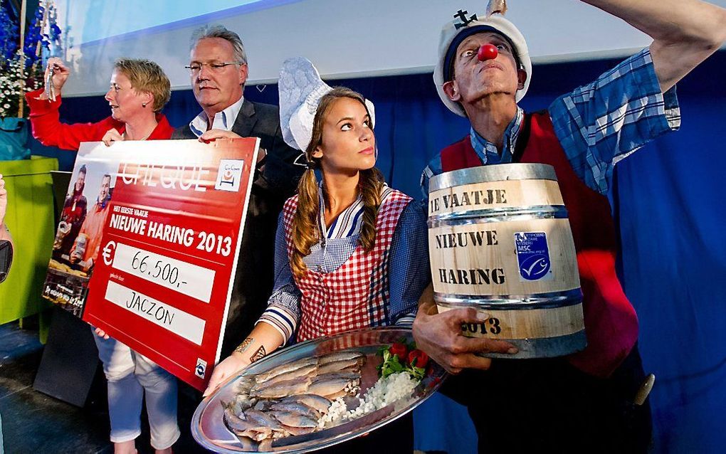 Directeur Barbara Hellendoorn-Mineur van Clinic Clowns en Auke van de Kerk van het bedrijf Jaczon tijdens de veiling van het eerste vaatje Hollandse Nieuwe 2013. beeld ANP