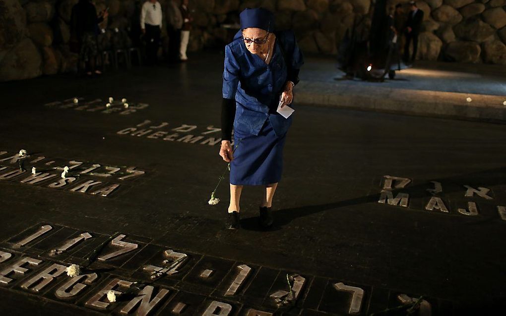 Een vrouw legt bloemen op een monument met de namen van de concentratiekampen in holocaustmuseum Yad Vashem, Jeruzalem. Foto EPA