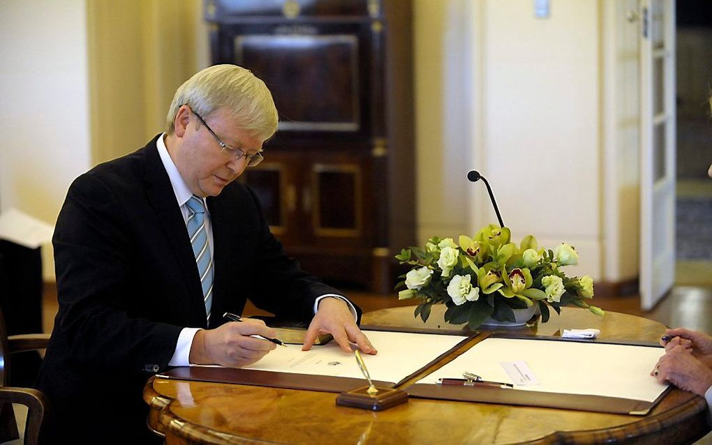 Rudd zet zijn handtekening als nieuwe premier van Australië. Foto EPA