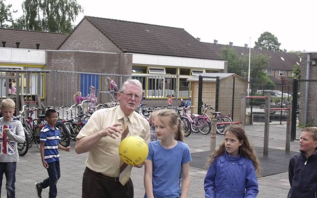 Directeur M. Karels tussen leerlingen van de ds. Johannes Bogermanschool in Capelle aan den IJssel. beeld Dick den Braber