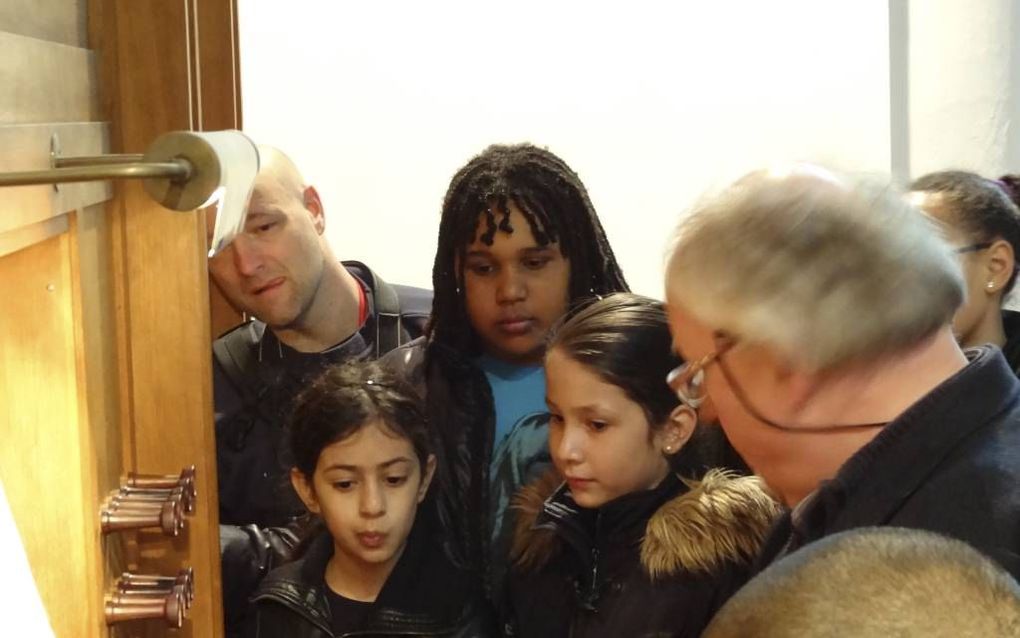 Organist Jos van der Kooy legt aan kinderen van groep 6 uit hoe een orgel werkt. Beeld Haags Orgel Kontakt