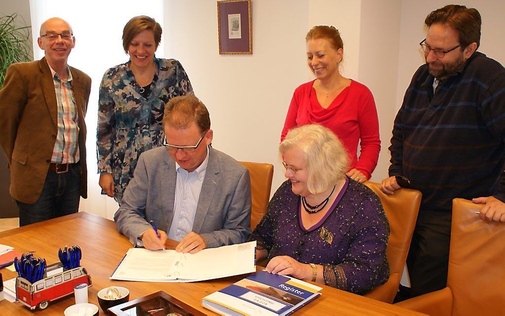 Ondertekening fusieakte door bestuursleden van de EA en EZ. V.l.n.r.: Adri Veldwijk, Karin Somhorst, Loek van der Laan, Jan Wessels (achter), Willem Smouter en Helma Rem (zittend). Beeld EA-EZA