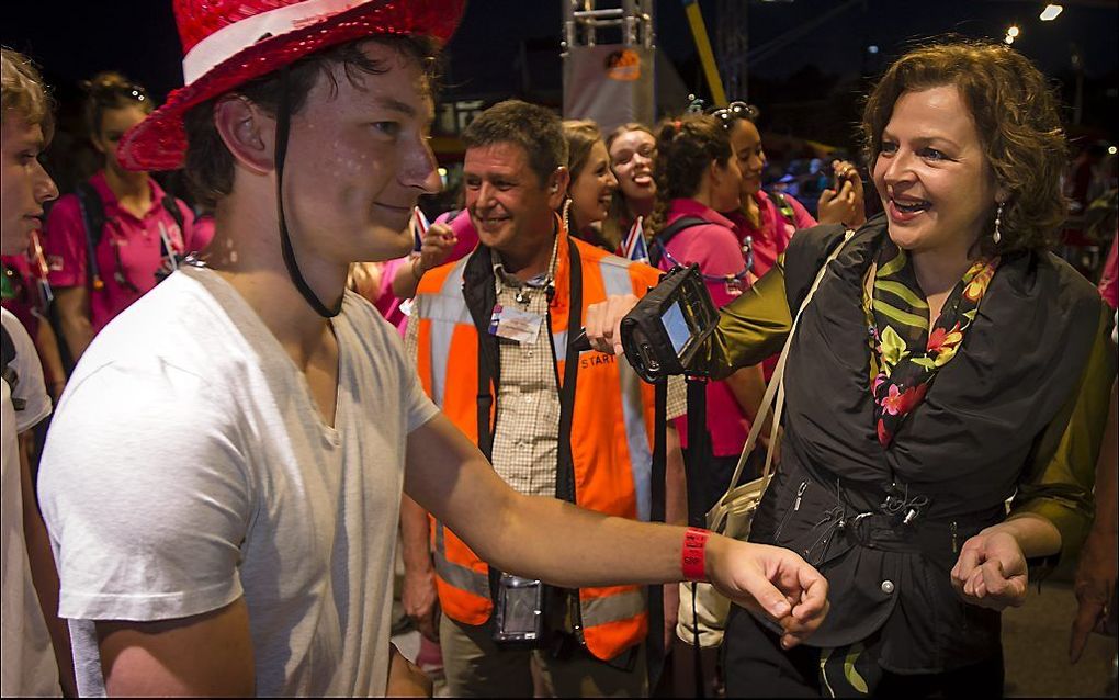 Minister Schippers scant na het startschot de polsbandjes van de eerste deelnemers aan de 97e editie van de Vierdaagse van Nijmegen. Foto ANP