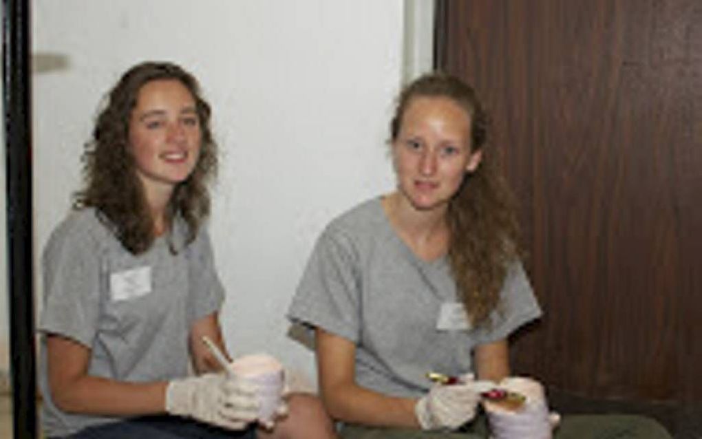 De Nederlandse vrijwilligers Johanna (l.) en Janneke Nicolai verven het trappenhuis van een flat in de Jeruzalemse wijk Kiryat HaYovel. Beeld Alfred Muller