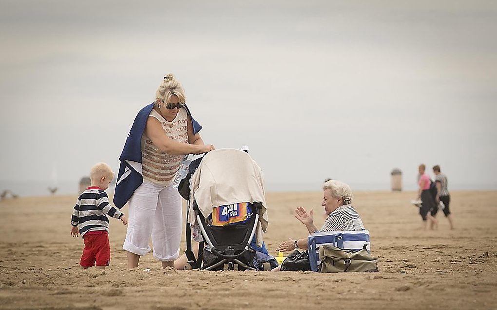 Badgasten zoeken zaterdag verkoeling op het strand van Scheveningen. Foto ANP