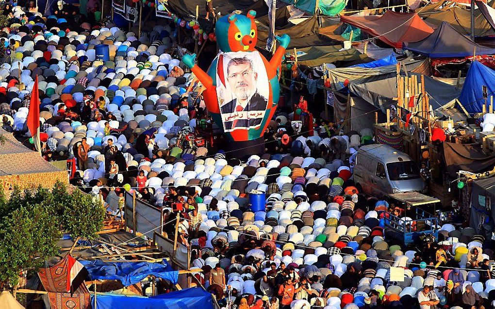 Aanhangers van Mursi bidden donderdag in Caïro. beeld EPA