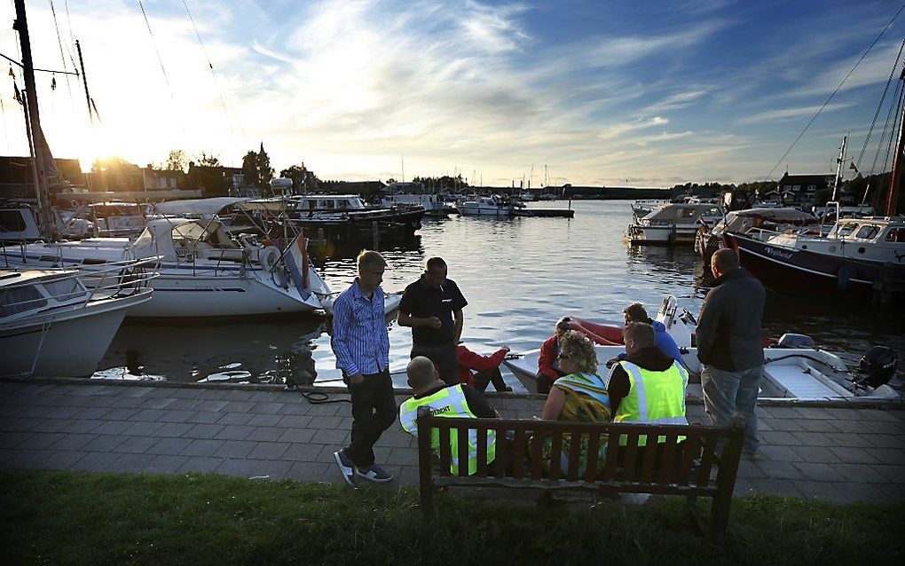 Hulpverleners zitten verslagen op een bankje in de jachthaven van Grouw. De politie heeft een stoffelijk overschot gevonden tijdens de zoektocht naar een vermist meisje van 17 uit Utrecht. Foto ANP