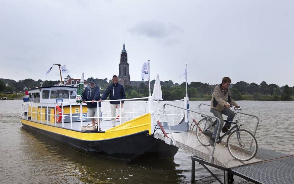 Het voetveer tussen Lienden en Rhenen heeft al 5000 passagiers overgezet. V.l.n.r. vrijwiligers Rob Baijens, Arie Bons en fietser Pieter van Leersum. Bons: „We hopen met het voetveer de Betuwe beter te ontsluiten.” beeld RD, Anton Dommerholt