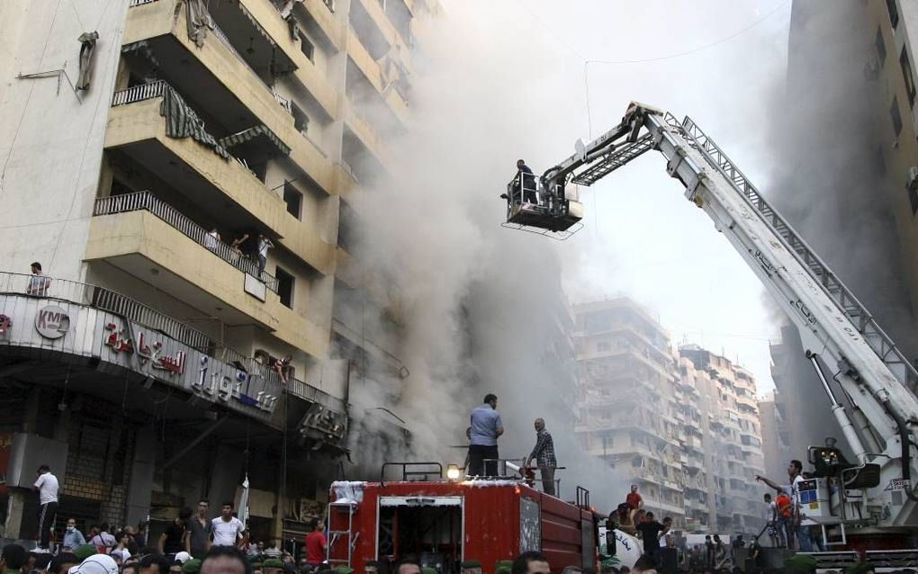 Een autobom in de Libanese hoofdstad Beiroet kostte donderdag zeker 22 mensen het leven. Analisten vrezen dat Libanon op deze manier kan worden meegesleurd in het Syrische conflict. Dat zou in het land een nieuwe burgeroorlog kunnen inhouden. Beeld EPA