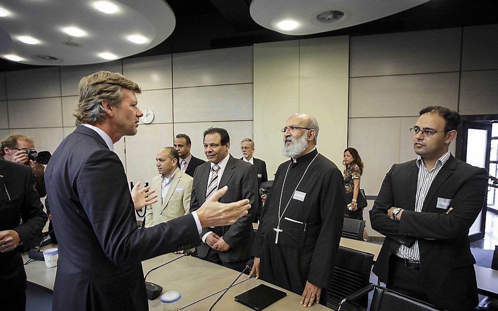 CU-Kamerlid Voordewind (l.) in gesprek met pastoor Jozef (tweede van rechts) in de Tweede Kamer. Beeld ANP