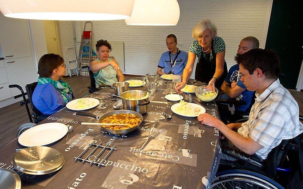 Bewoners gebruiken de avondmaaltijd, die door een vrijwilliger is bereid. Foto RD, Anton Dommerholt.