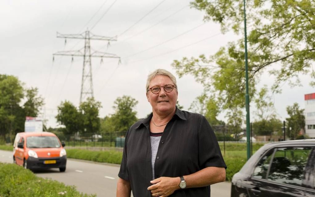 Els van Dijk vlak bij de plaats in Veenendaal waar tot een paar jaar geleden haar ouderlijk huis stond. „Je kon op het terrein eromheen heerlijk buiten spelen.” Op de achtergrond de elektriciteitsmast waar ze ooit in klom. beeld RD, André Dorst