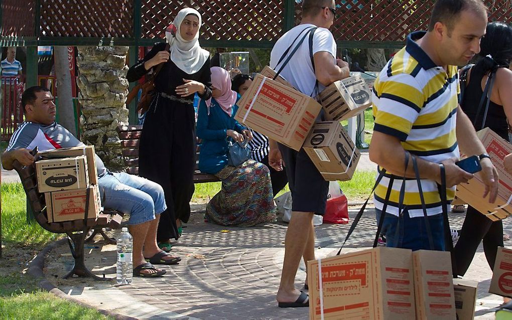 Inwoners van Kiryat Motzkin, ten noorden van Haifa, wachten op hun beurt om hun gasmaskers te laten controleren. Foto EPA