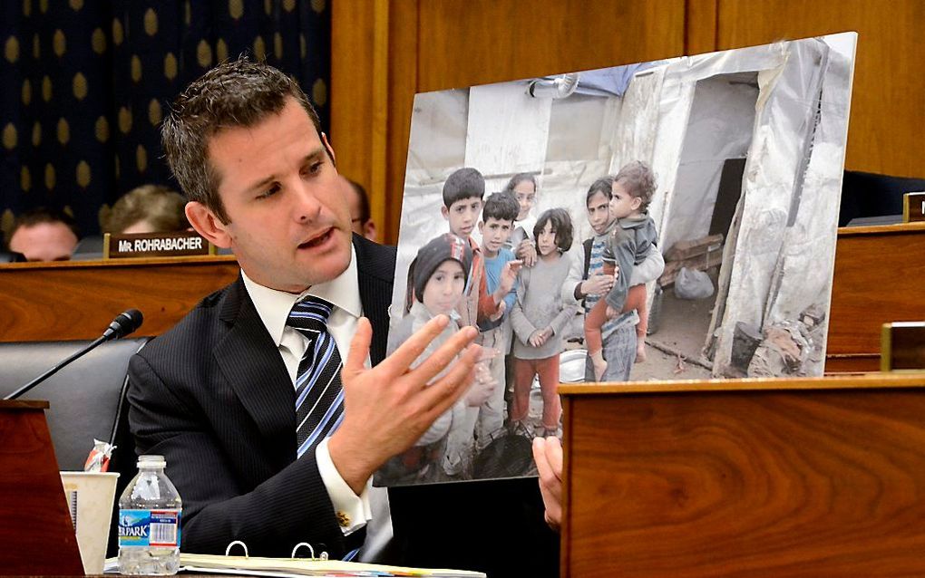 Republikein Adam Kinzinger laat aan de hand van een foto van Syrische kinderen de gevolgen van gifgas sarin zien. Foto EPA