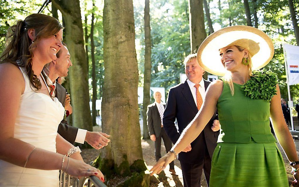 Een bruidspaar begroet koning Willem-Alexander en koningin Máxima als zij arriveren bij Paleis Het Loo. Foto ANP