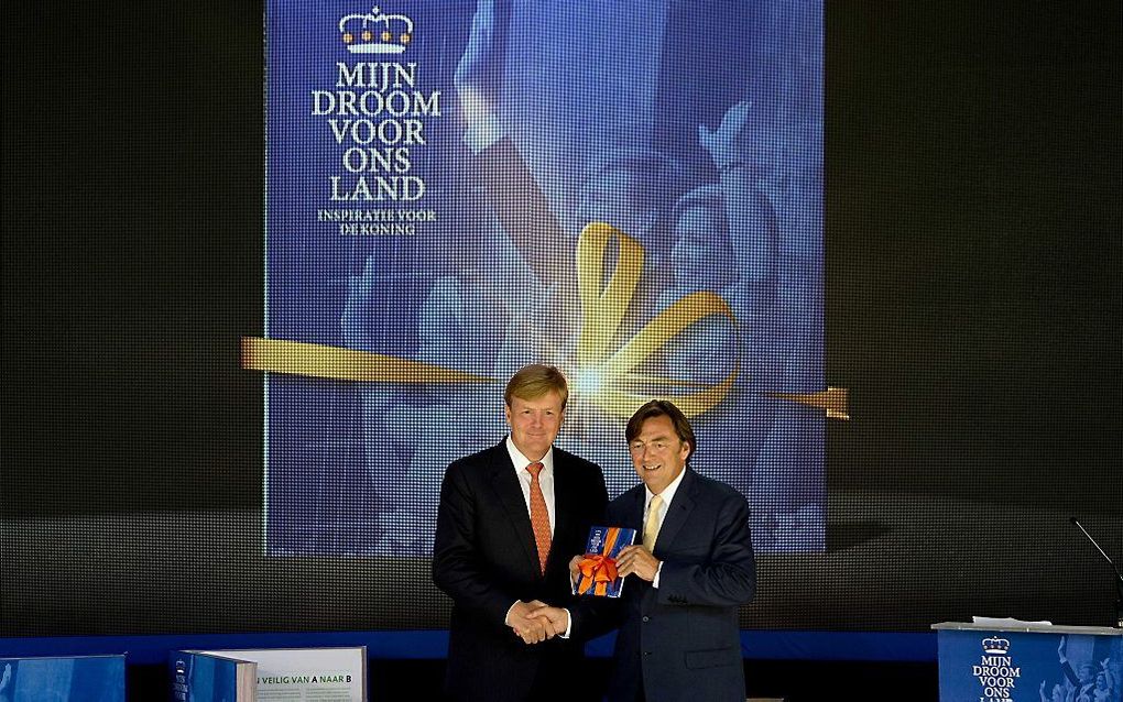 Hans Weijers (R), voorzitter van het Nationaal Comité Inhuldiging, overhandigt het eerste exemplaar van het Droomboek aan koning Willem Alexander op Paleis Het Loo. Foto ANP