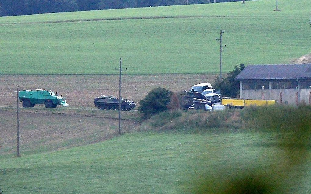 Pantservoertuigen bij de boerderij waar de schutter zich zou ophouden. Foto EPA