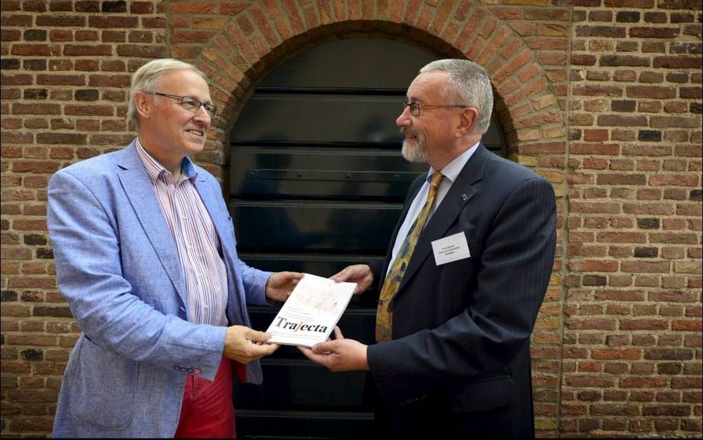 Oud-redactiesecretaris prof. dr. Theo Clemen (l.) krijgt van redactievoorzitter prof. dr. Peter Nissen het vernieuwde tijdschrift Trajecta gepresenteerd in het Utrechtse museum Catharijneconvent. beeld Ton Borsboom