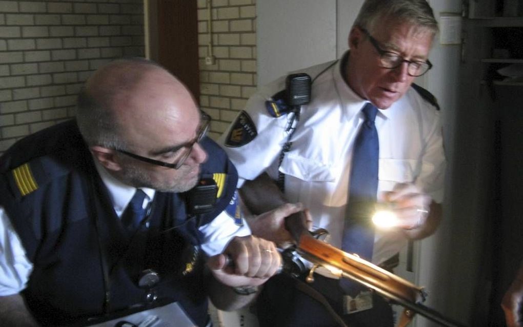 GOES. Politievrijwilligers Frank Op de Beek (l.) en Peter Jacobs zoeken naar een registratienummer op een wapen. Foto RD