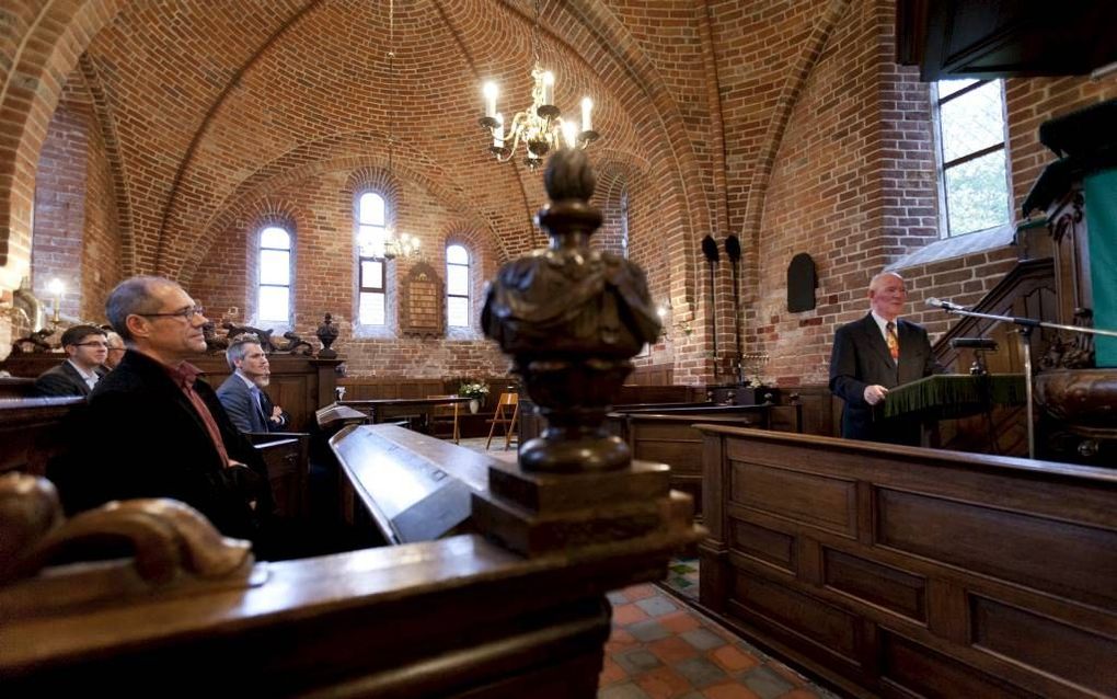 Voorzitter Gert van den Bremen van de Stichting Oude Groninger Kerken aan het woord, vrijdagmiddag in Ulrum. Links in de herenbanken kerkrentmeester Dick Ronner. beeld Jan-Willem van Vliet