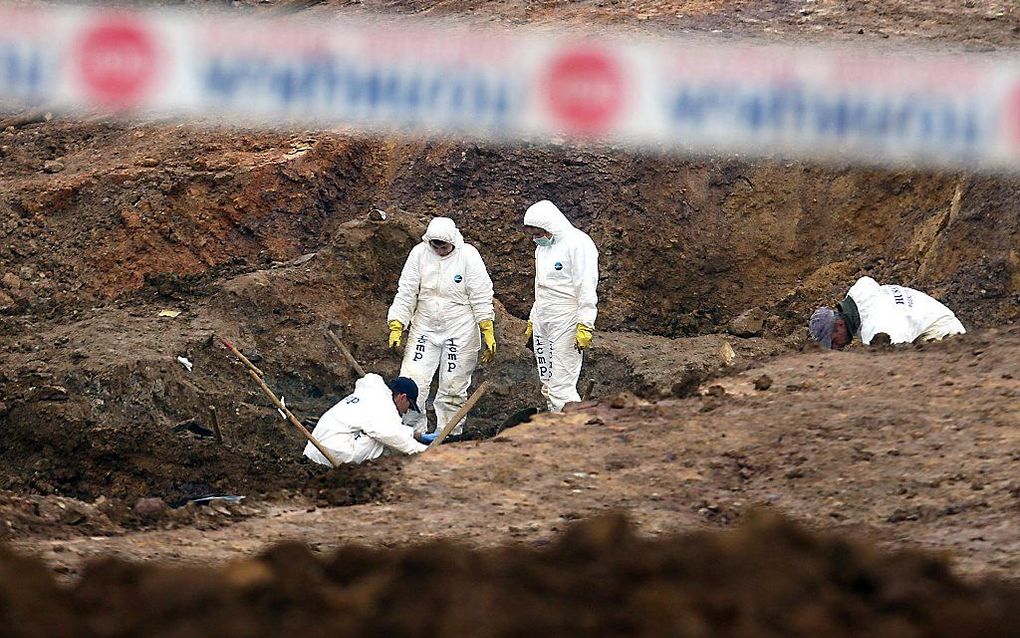 Forensisch experts bij het massagraf in Tomasica. Foto EPA