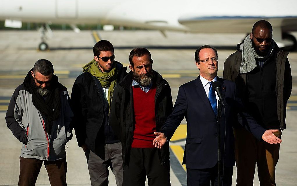 De Franse president François Hollande houdt een toespraak naar aanleiding van de veilige terugkeer van de losgelaten gijzelaars Marc Feret, Pierre Legrand, Daniel Larribe en Thierry Dol (v.l.n.r.). beeld EPA