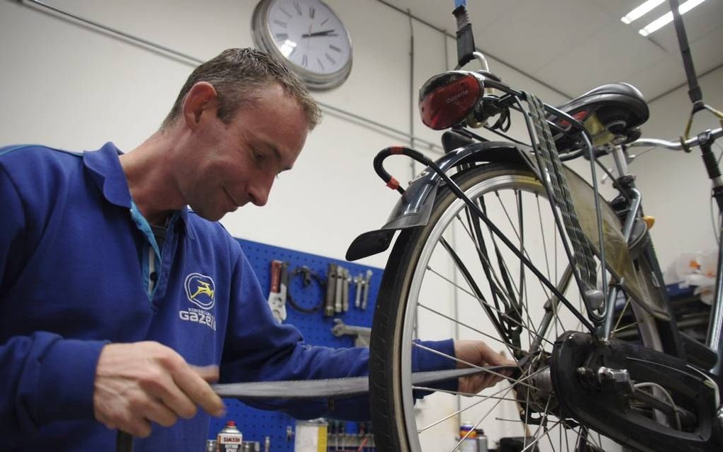 Fietsenmaker Robin Bijl in Bergambacht repareert gratis fietsbanden die zijn lekgeraakt door de wegverharding op de Lekdijk. beeld Wim de Jongste