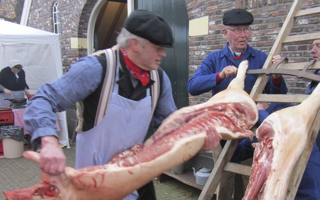 De Enterse slager Vincent Roetgerink haalt tijdens de jaarlijkse slachtvisite een varken van de ladder. beeld Gerrit Dannenberg