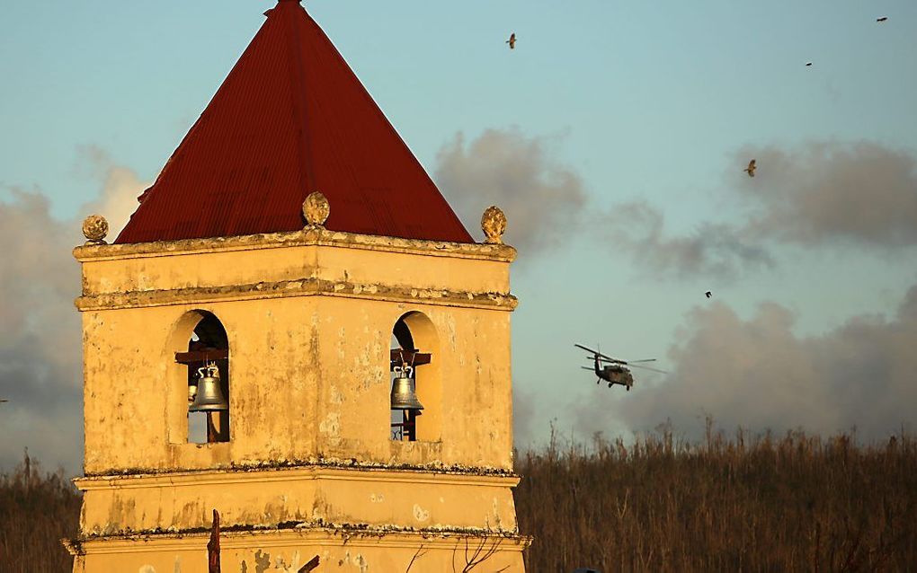 Een helikopter van de Amerikaanse marine vliegt boven het verwoeste dorp Balangiga op het eiland Samar in de Filipijnen. beeld EPA