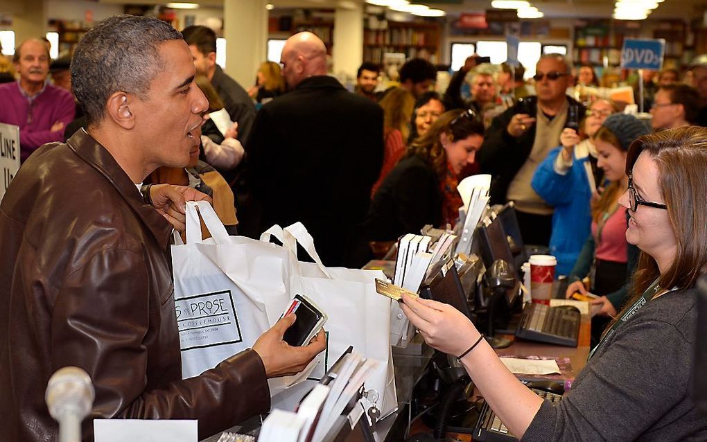 De Amerikaanse president Obama doet inkopen bij een boekhandel. beeld EPA