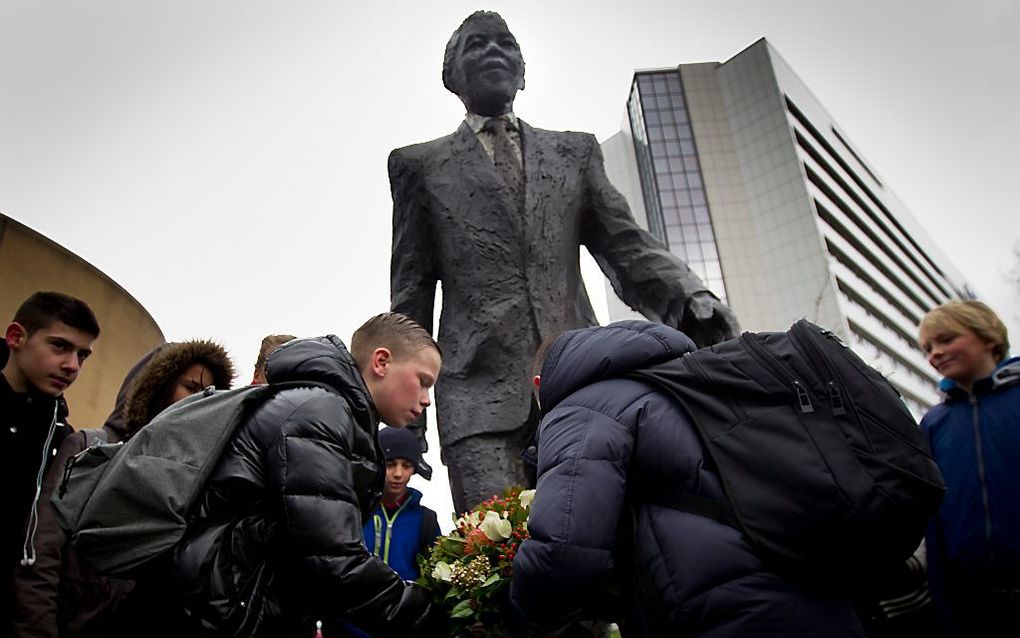 Leerlingen van het Maris College uit Den Haag leggen een krans bij het standbeeld van Nelson Mandela. Foto ANP